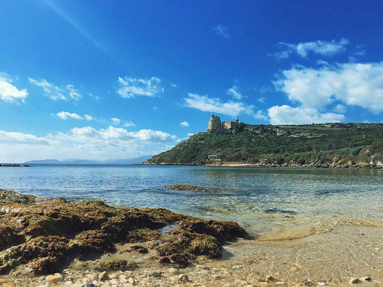 La spiaggia di Calamosca con la torre spagnola sul promontorio in fondo