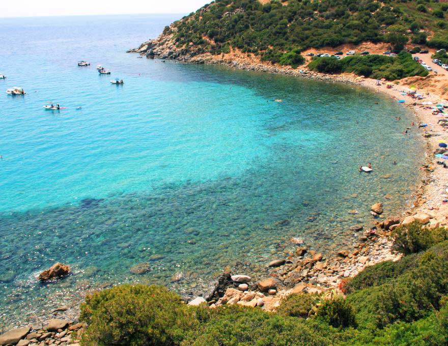 La baia di Cala Regina con le barche ormeggiate sull'acqua turchese