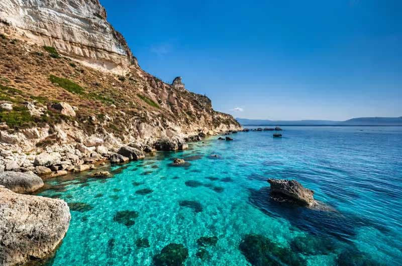 Le falesie calcaree della Sella del Diavolo a picco sull'acqua turchese